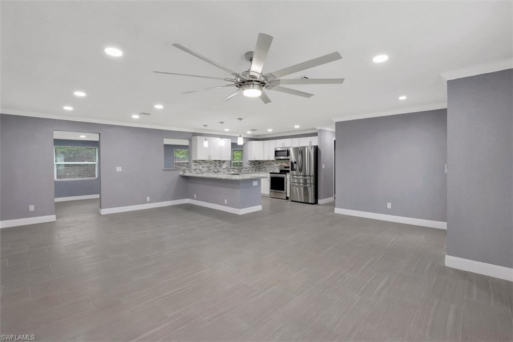 19109 Birch Road Fort Myers, FL 33967 - Photo 1 of 24 an empty room with a kitchen and a ceiling fan