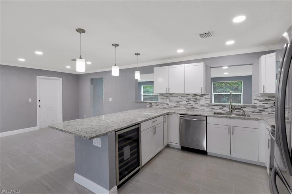 19109 Birch Road Fort Myers, FL 33967 - Photo 4 of 24 a kitchen with granite countertop a sink and white cabinets