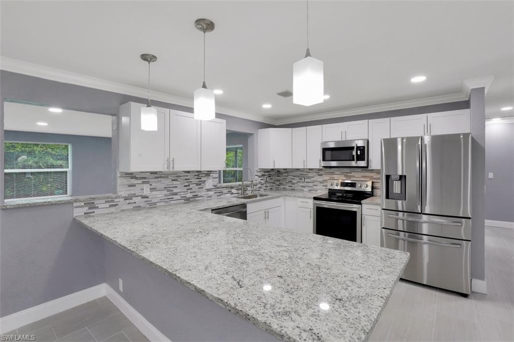 19109 Birch Road Fort Myers, FL 33967 - Photo 7 of 24 a kitchen with stainless steel appliances granite countertop a sink refrigerator and microwave