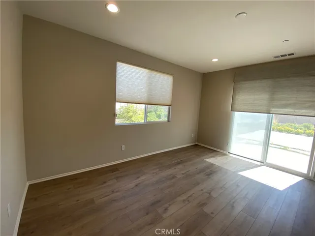 a large kitchen with kitchen island a refrigerator a stove a sink dishwasher and a oven with wooden floor