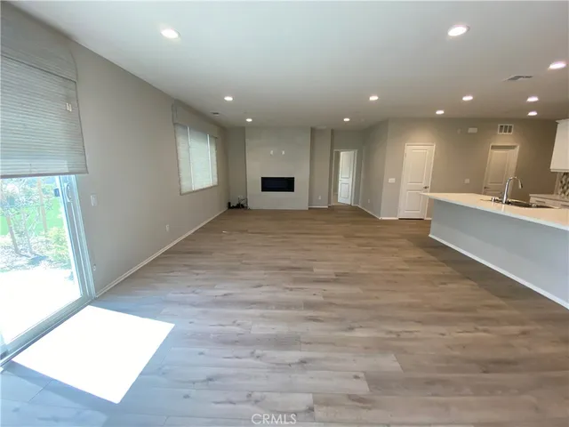 a view of kitchen with kitchen island a sink wooden floor and living room view