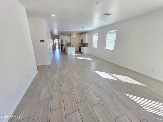 a view of a living room hardwood floor and a kitchen