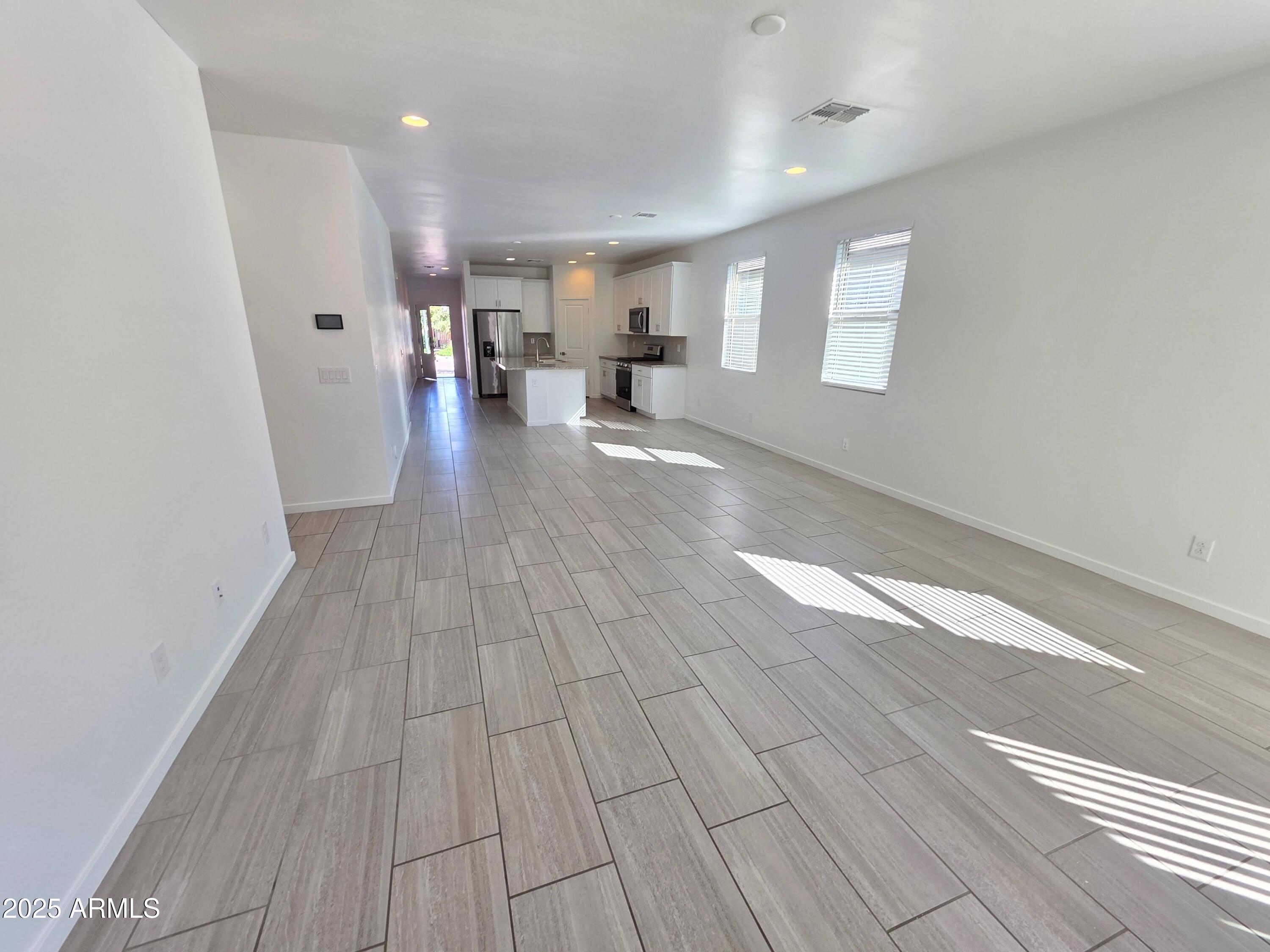 4214 North 68th Lane Phoenix, AZ 85043 - Photo 11 of 13 a view of a living room hardwood floor and a kitchen