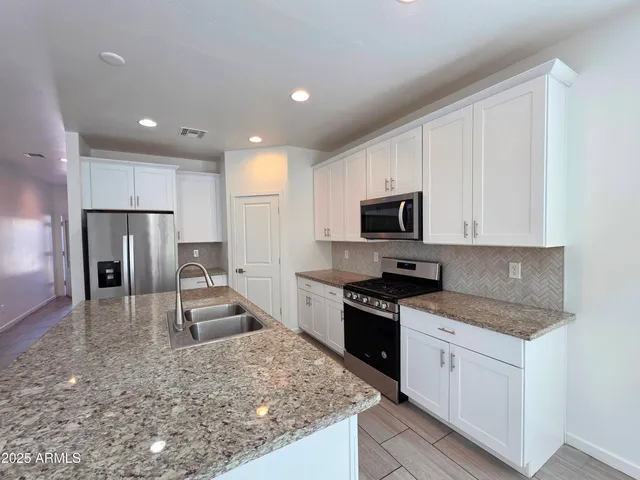 a large kitchen with a stove a sink and a refrigerator