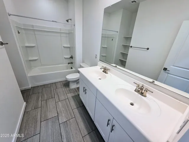 a bathroom with a tub sink toilet and a mirror