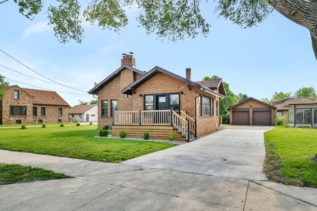 a front view of a house with a yard and trees