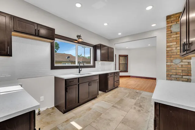 a large kitchen with stainless steel appliances a sink stove and cabinets