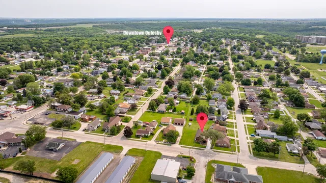 an aerial view of residential houses with outdoor space and trees
