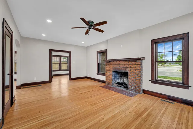 a view of a livingroom with a fireplace window and wooden floor