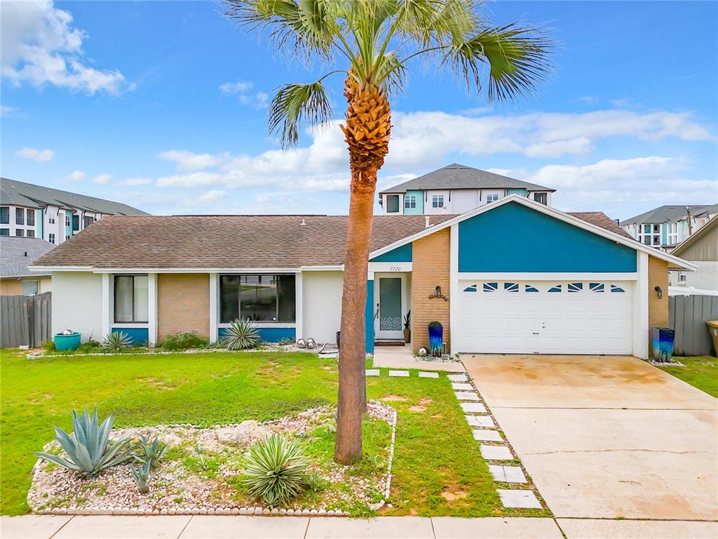 a view of a white house with a big yard and potted plants
