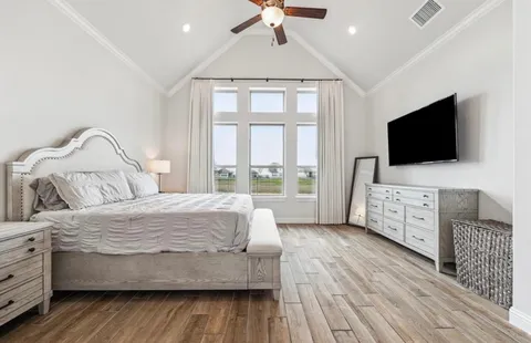 a bedroom with a bed and a flat screen tv