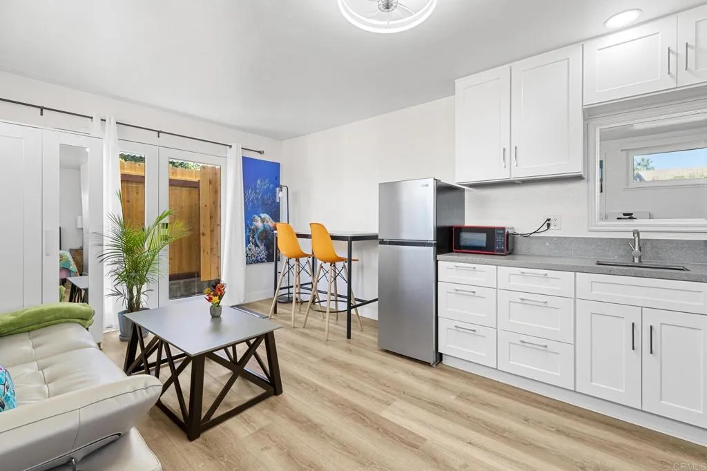 1153 Aloha Drive Encinitas, CA 92024 - Photo 43 of 50 a kitchen with stainless steel appliances granite countertop a table and chairs in it