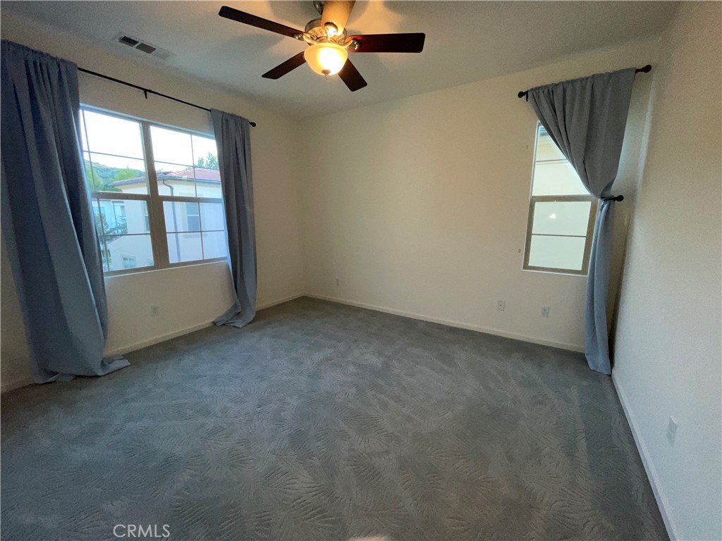 22083 Propello Drive Saugus, CA 91350 - Photo 8 of 21 en empty room with windows and ceiling fan