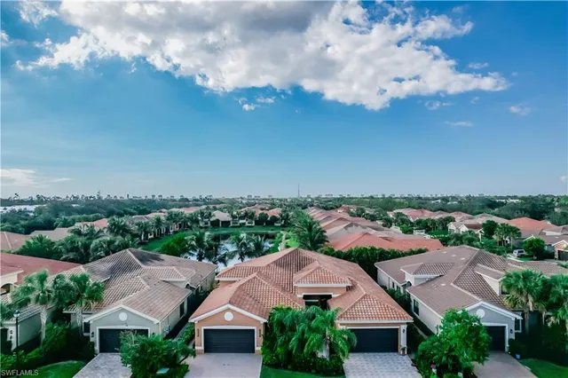 an aerial view of residential houses with outdoor space and trees