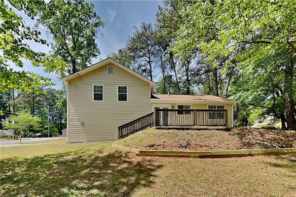 a view of house with yard and trees in the background