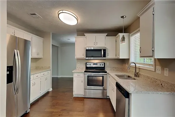 a kitchen with white cabinets and stainless steel appliances