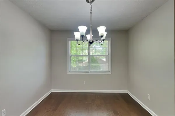 a view of a room that has a chandelier fan and a large window