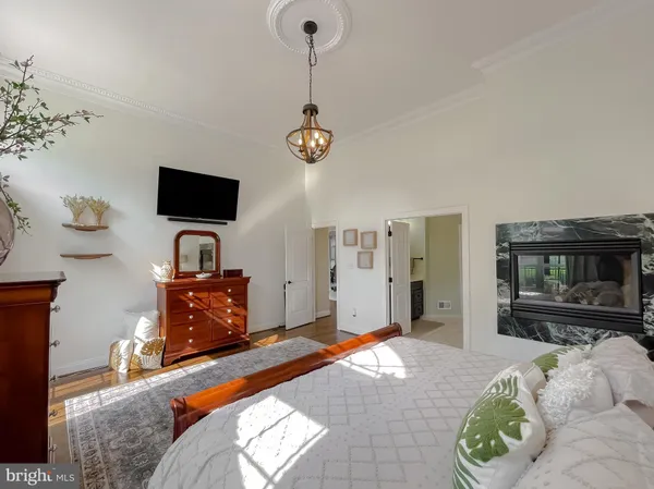 a bedroom with a bed a large window and wooden floor