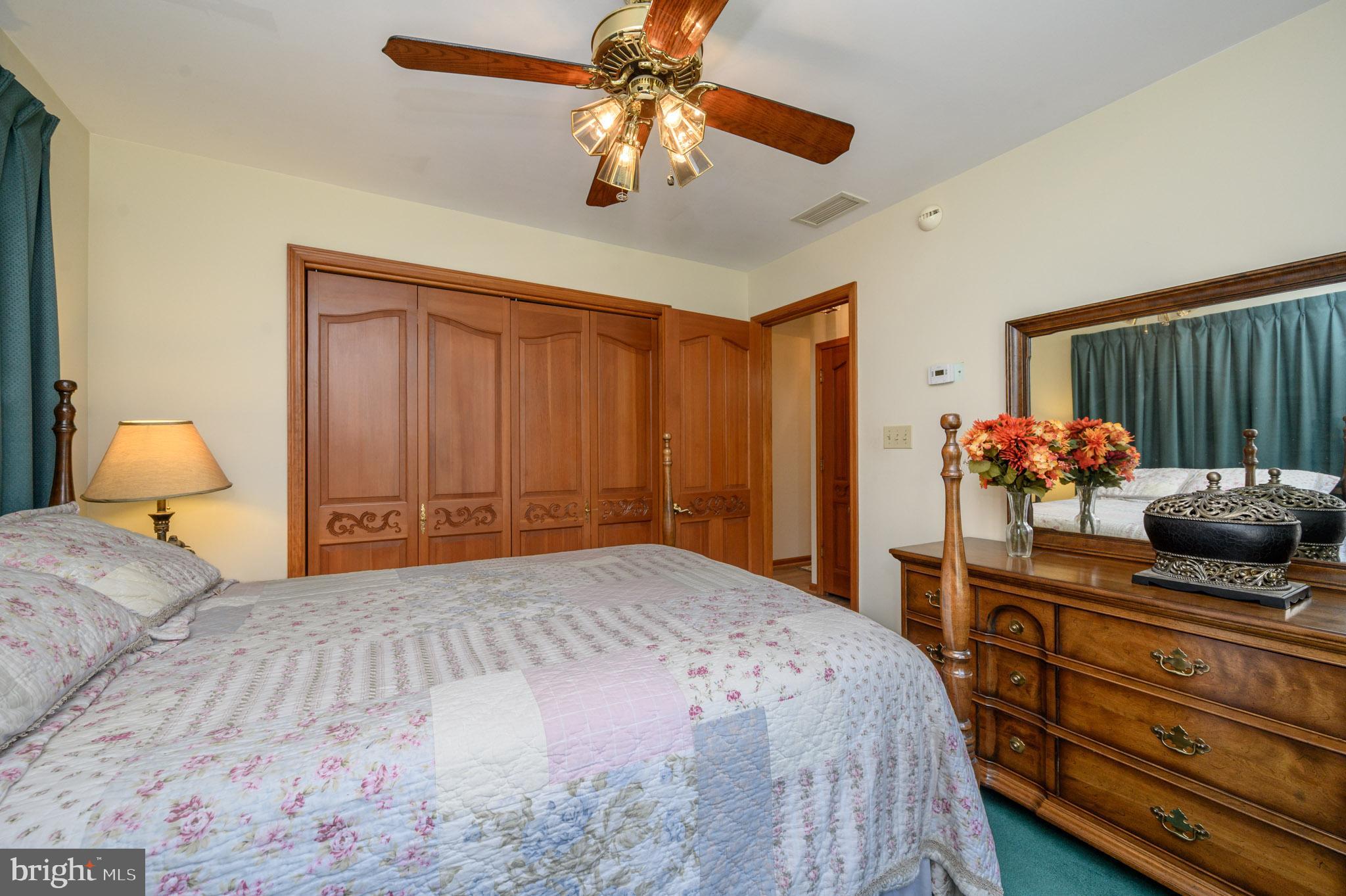 1404 Columbus Road Burlington, NJ 08016 - Photo 24 of 55 a bedroom with a bed potted plant on dresser and a chandelier