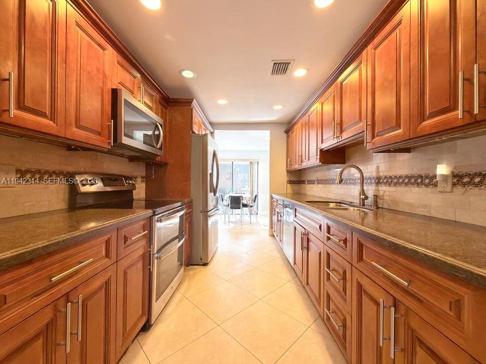 205 Bonnie Brae Way, Unit 33 Hollywood, FL 33021 - Photo 6 of 43 a large kitchen with stainless steel appliances granite countertop a lot of counter space and a sink