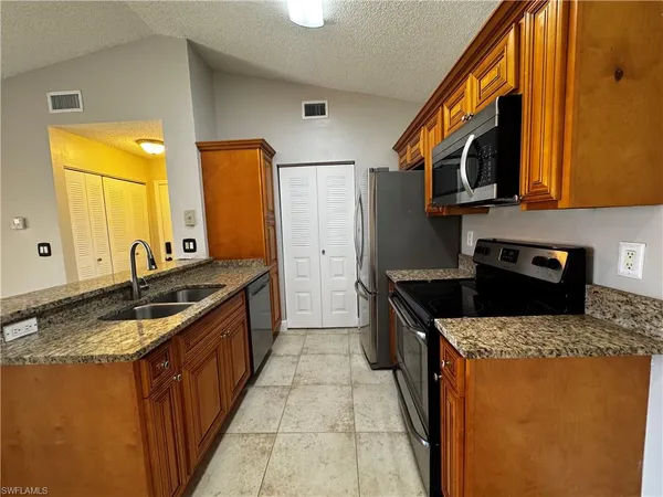 a kitchen with stainless steel appliances granite countertop a sink and a stove