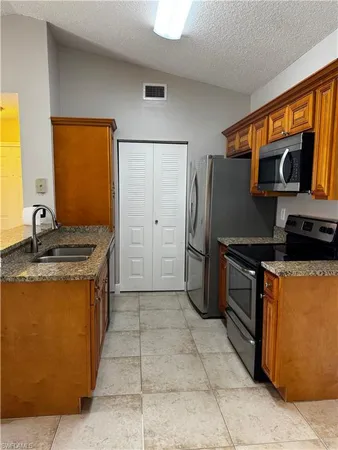 a kitchen with stainless steel appliances granite countertop a stove refrigerator and microwave