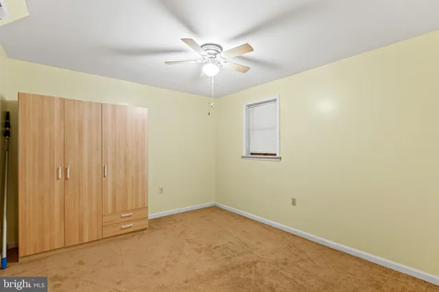 an empty room with a ceiling fan and wooden floor