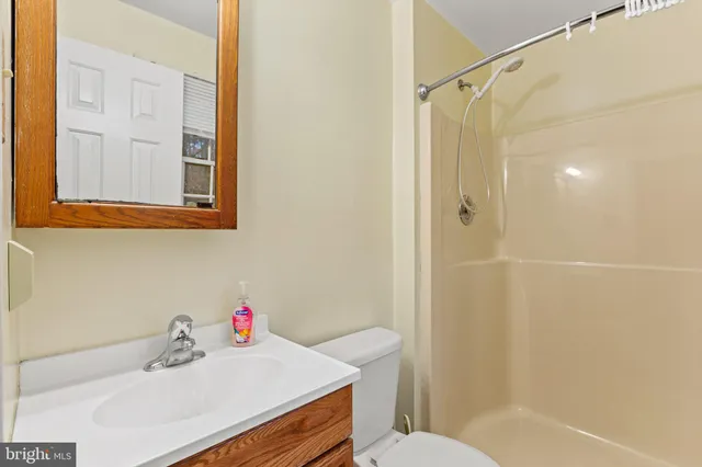 a bathroom with a sink vanity mirror and toilet