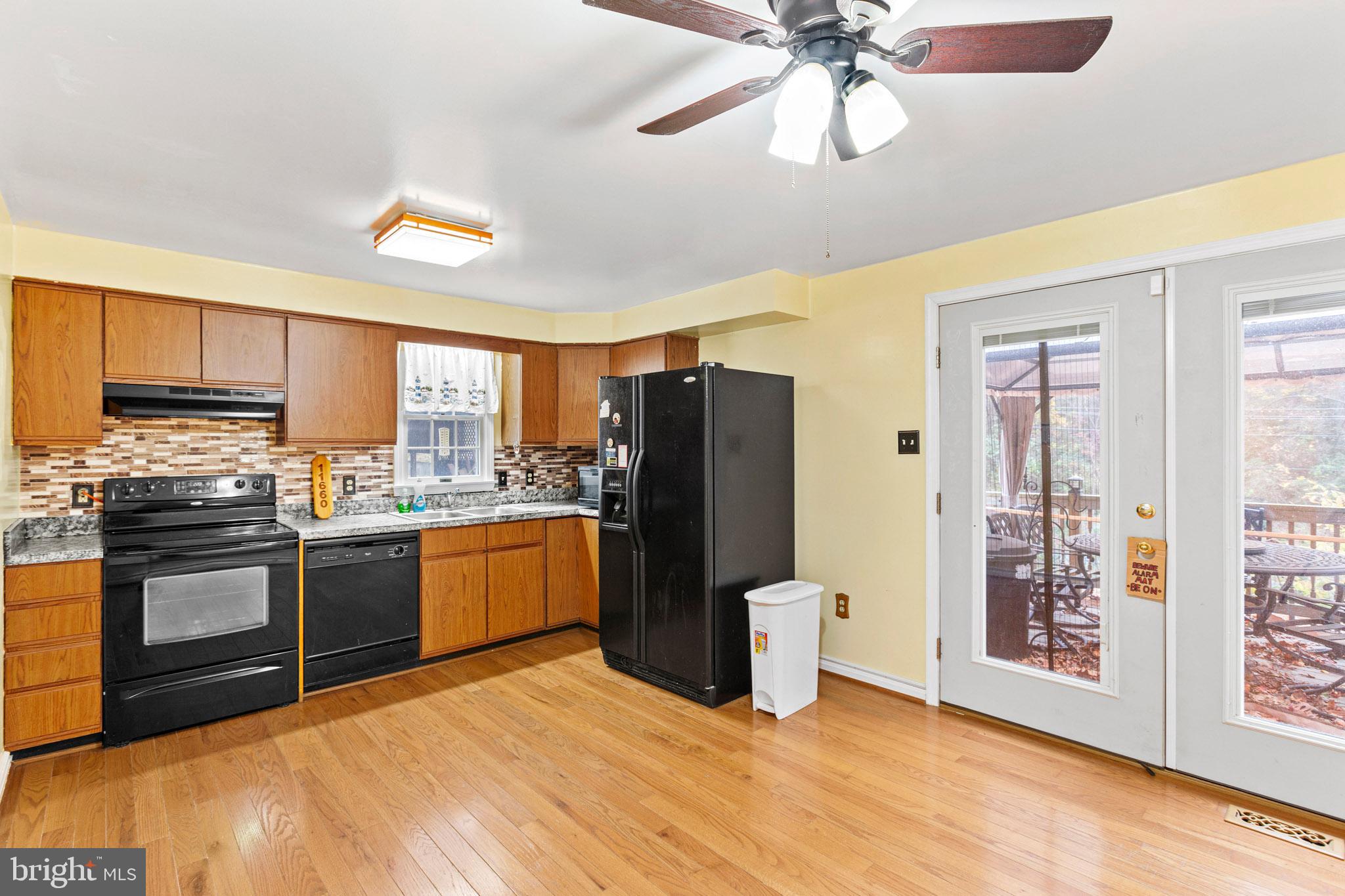 11660 Big Sandy Run Road Lusby, MD 20657 - Photo 7 of 30 a kitchen with a refrigerator and a stove top oven