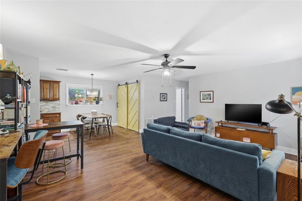 16 Coffee Tavern Road Bedford, TX 76022 - Photo 5 of 24 Open-concept living space featuring wood-finish flooring, a ceiling fan with integrated lighting, and light gray wall paint
