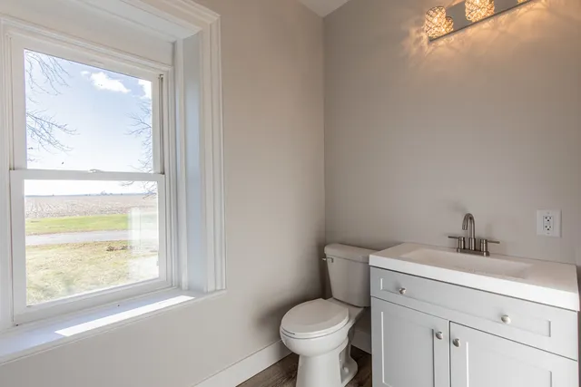 a view of empty room with wooden floor and a window