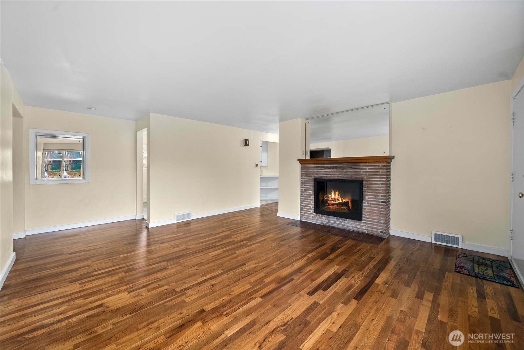9717 14th Avenue Northwest Seattle, WA 98117 - Photo 4 of 32 a view of an empty room with wooden floor fireplace and a window