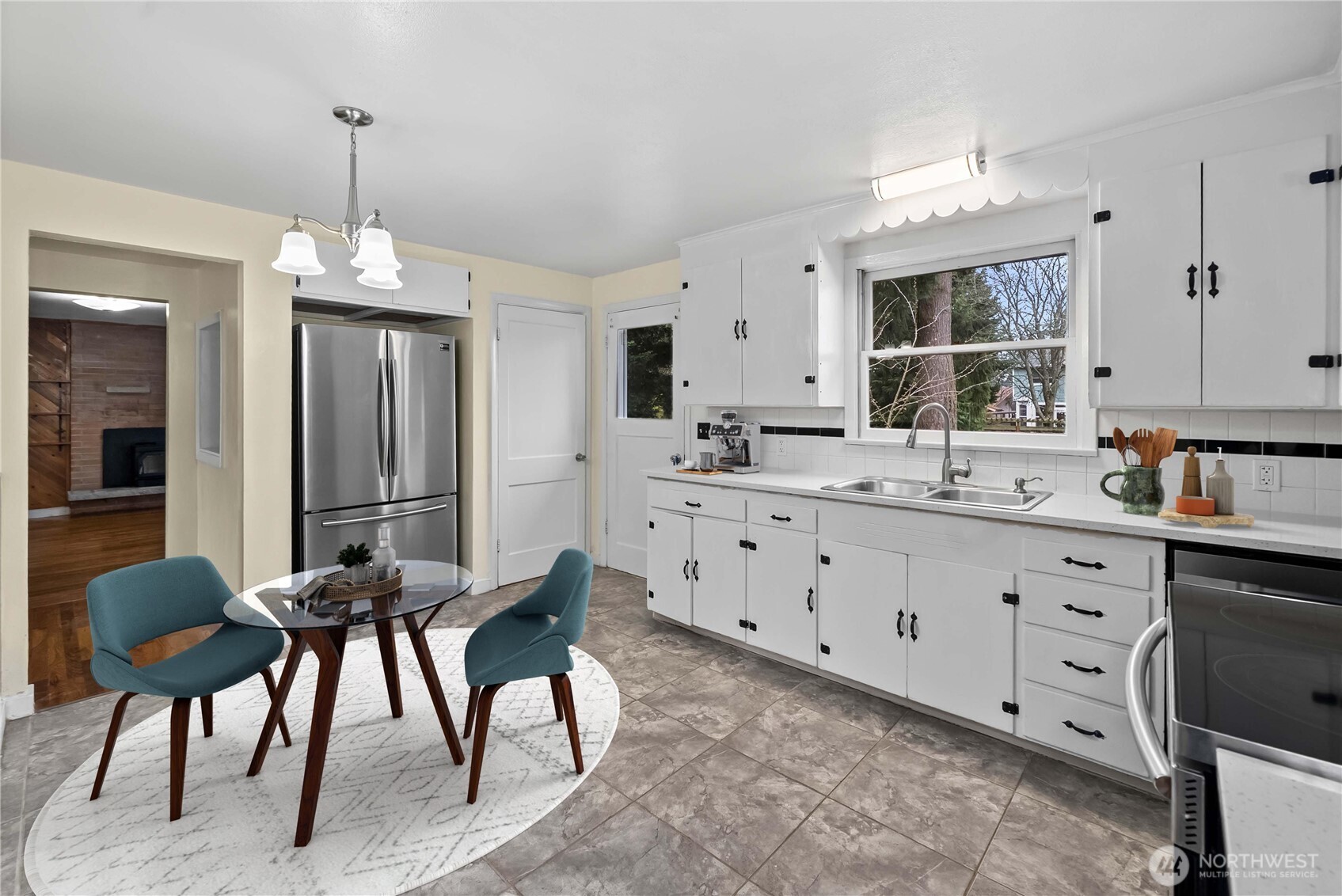 9717 14th Avenue Northwest Seattle, WA 98117 - Photo 5 of 32 a kitchen with granite countertop a table chairs sink and cabinets