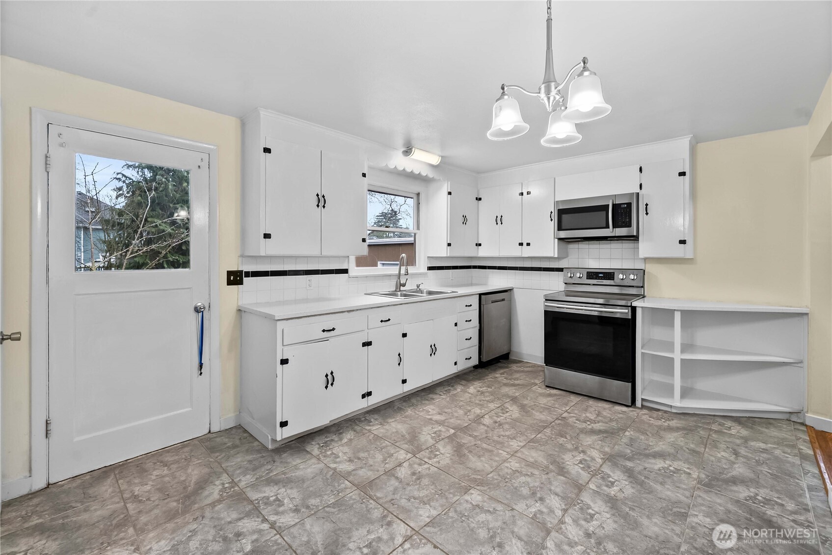 9717 14th Avenue Northwest Seattle, WA 98117 - Photo 6 of 32 a kitchen with stainless steel appliances a stove sink and microwave
