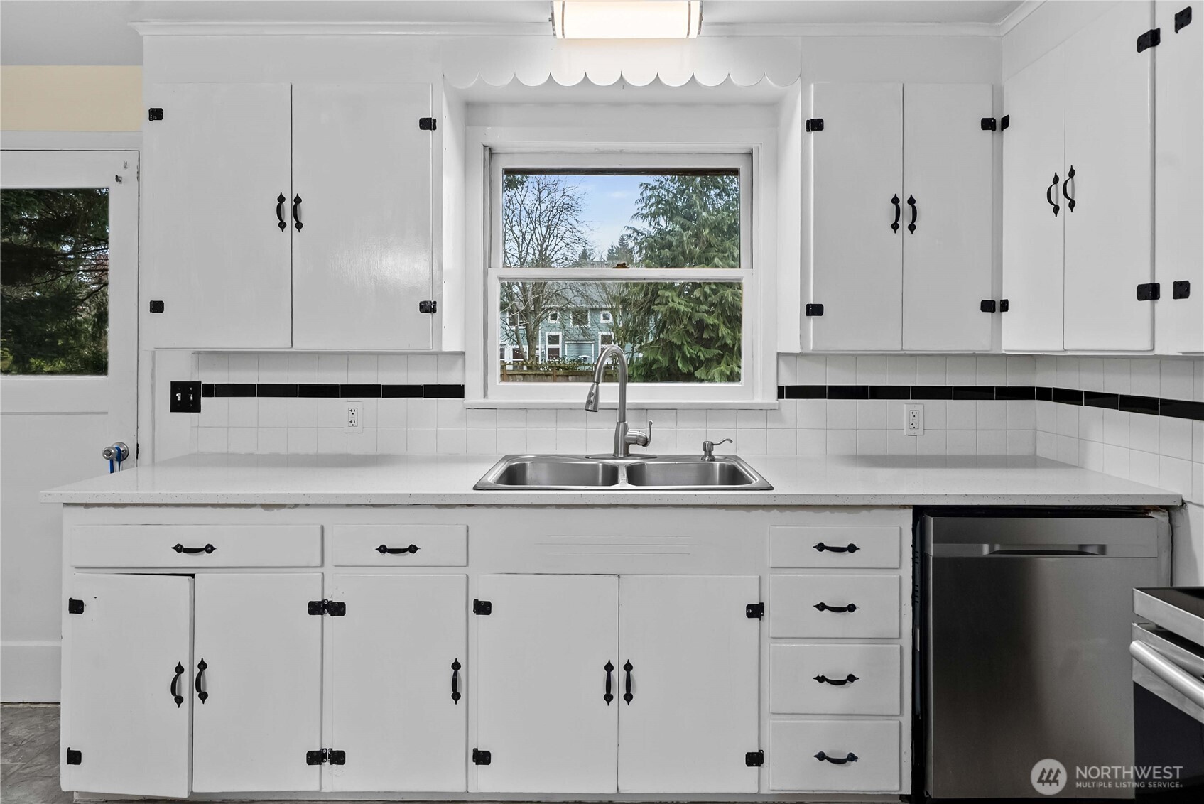 9717 14th Avenue Northwest Seattle, WA 98117 - Photo 7 of 32 a kitchen with granite countertop white cabinets and sink