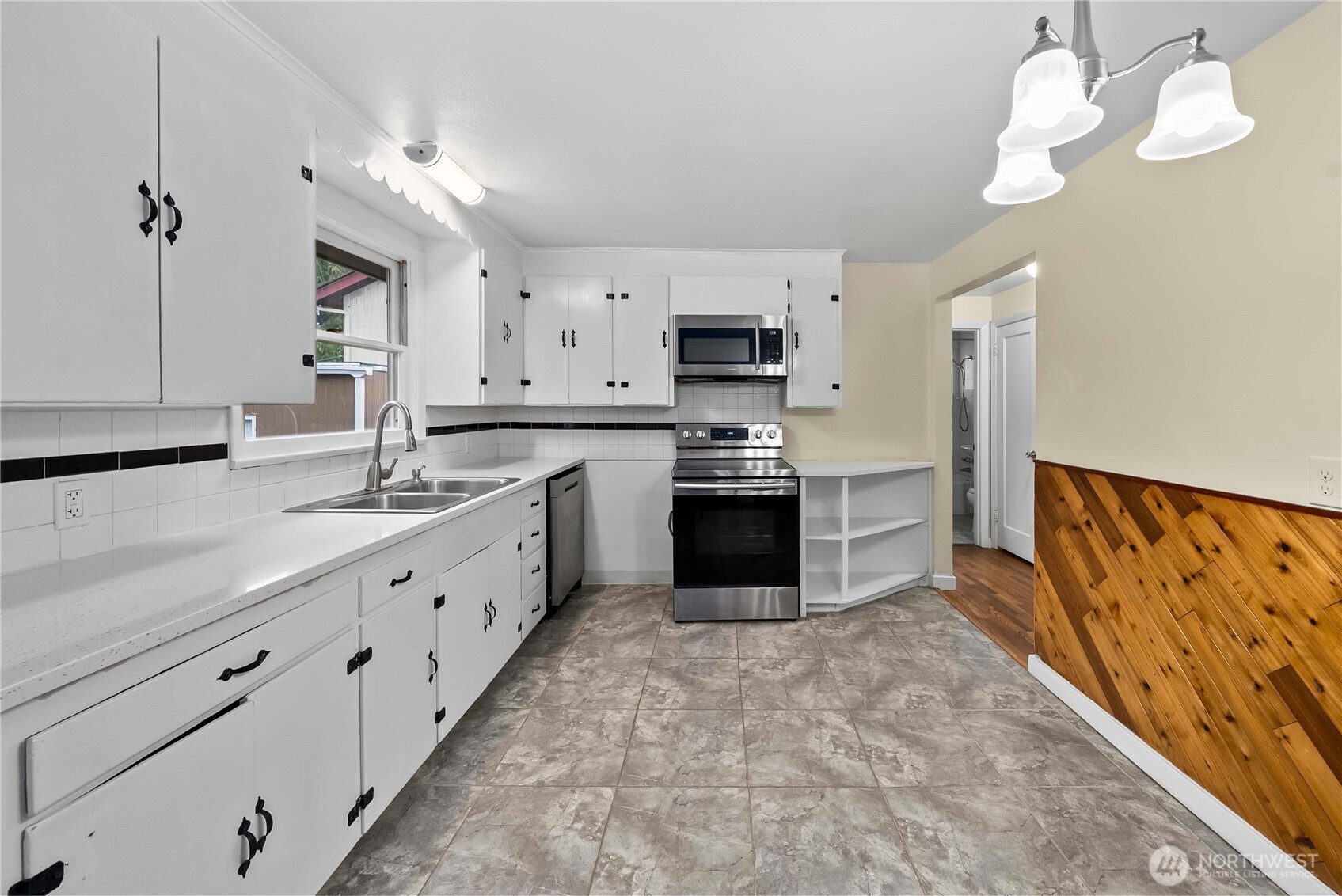 9717 14th Avenue Northwest Seattle, WA 98117 - Photo 8 of 32 a large kitchen with stainless steel appliances granite countertop a sink counter space cabinets and a stove