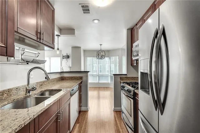 a kitchen with stainless steel appliances granite countertop a sink stove and refrigerator