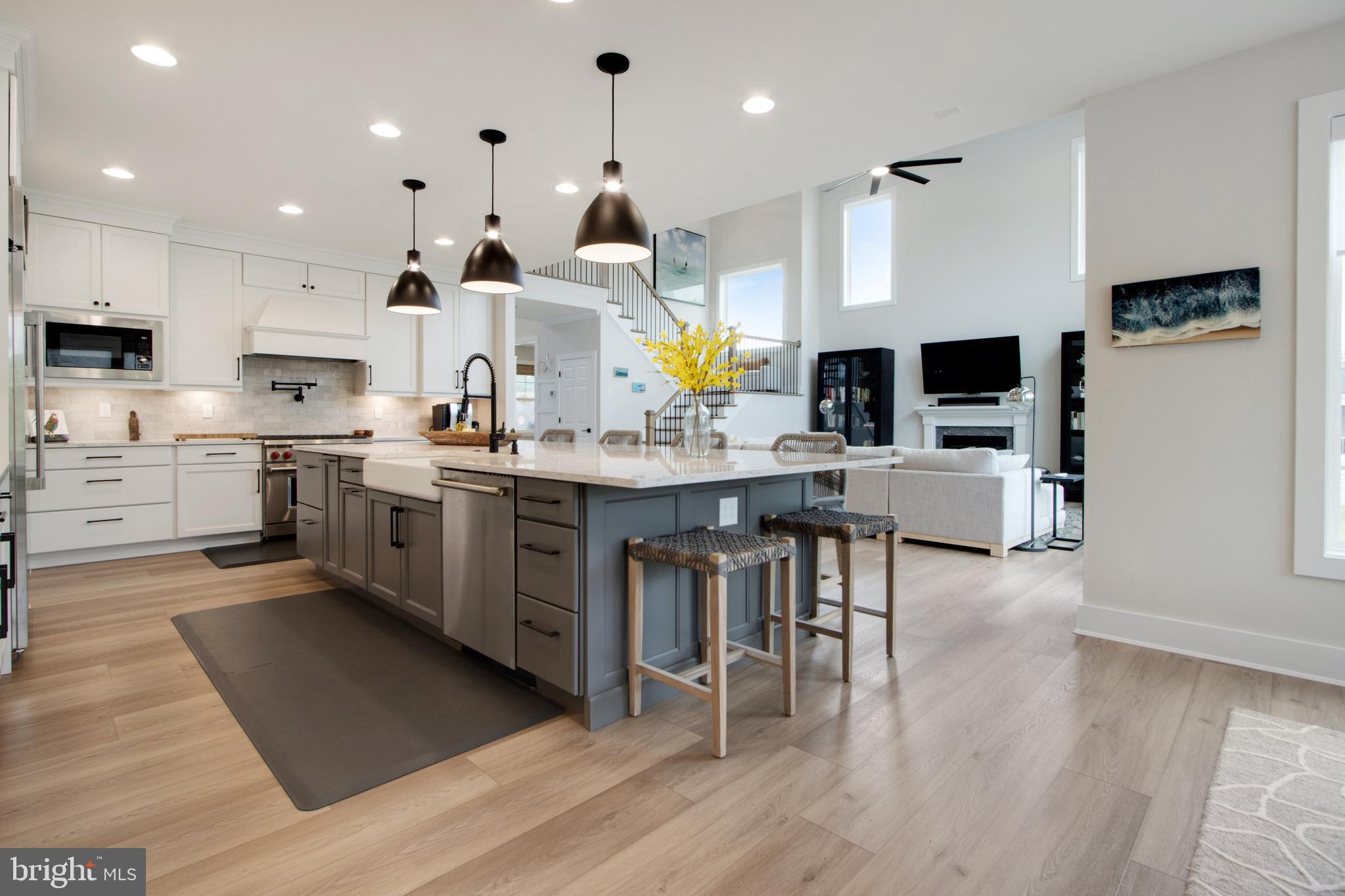 16672 New Road Lewes, DE 19958 - Photo 22 of 55 a open kitchen with stainless steel appliances granite countertop a stove refrigerator and dining table with wooden floor