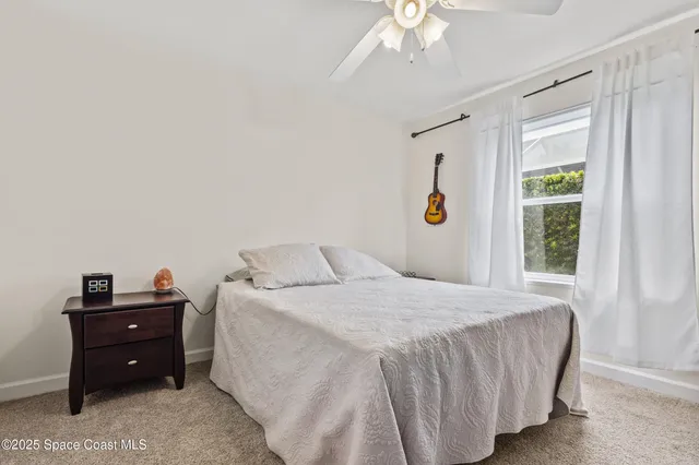 a front view of a house with a yard and potted plants