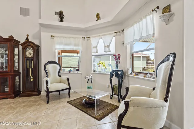 a very nice looking dining room with kitchen island furniture a chandelier fan and a kitchen view
