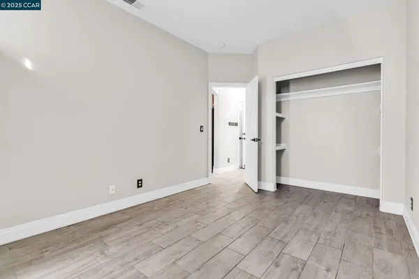an empty room with wooden floor and entrance