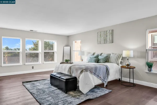 a spacious bedroom with a bed couch and a large window