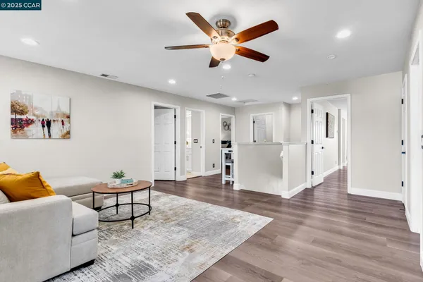 a living room with furniture and a wooden floor