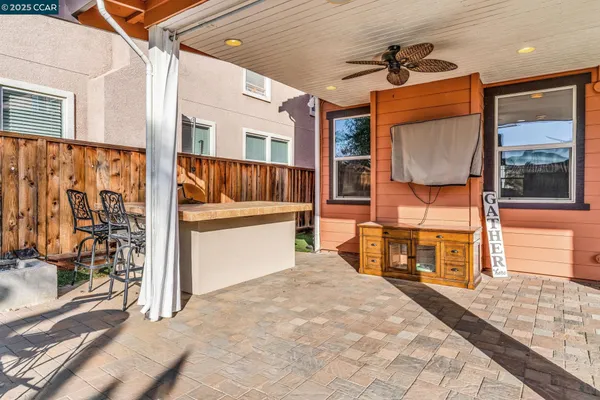 a view of living room kitchen with stainless steel appliances wooden floor and table chair
