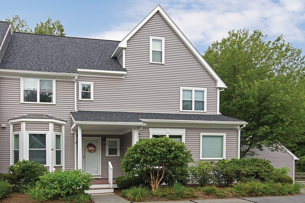 a front view of a house with a yard and potted plants