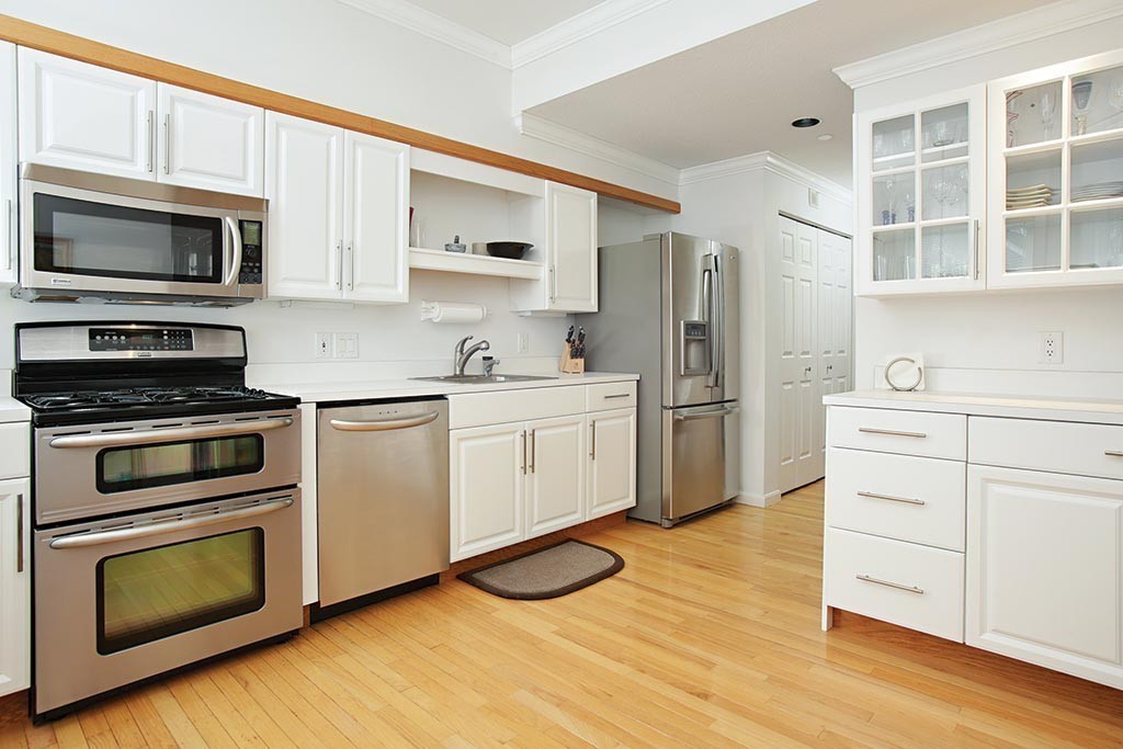 9 Maple Ridge Drive, Unit 9 Burlington, MA 01803 - Photo 4 of 11 a kitchen with stainless steel appliances white cabinets and wooden floor
