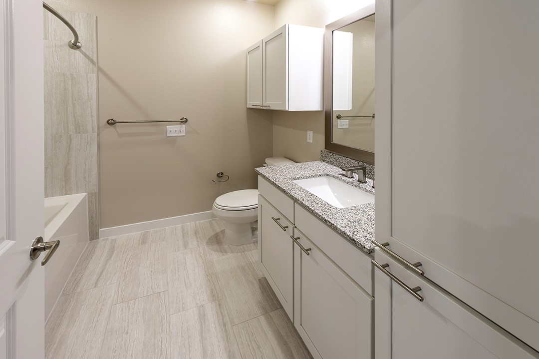 1724 Partnership Way, Unit 3101 Katy, TX 77449 - Photo 24 of 30 a bathroom with a granite countertop sink a toilet and a mirror