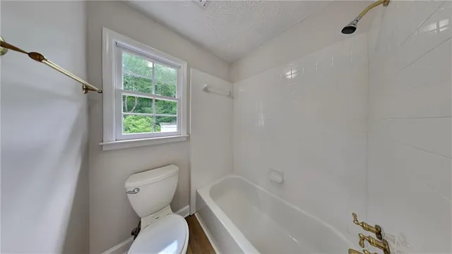 a white toilet sitting next to a bath tub