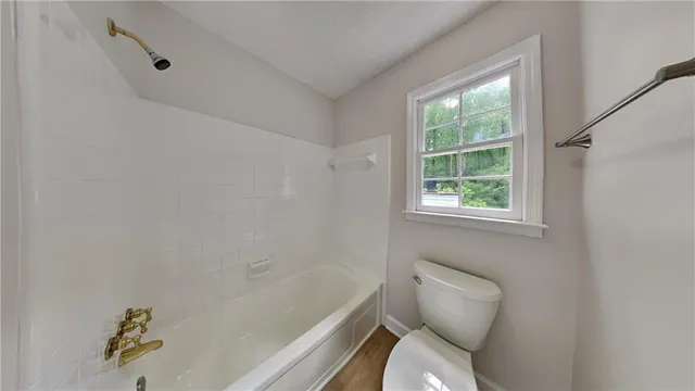 a white toilet sitting next to a bath tub
