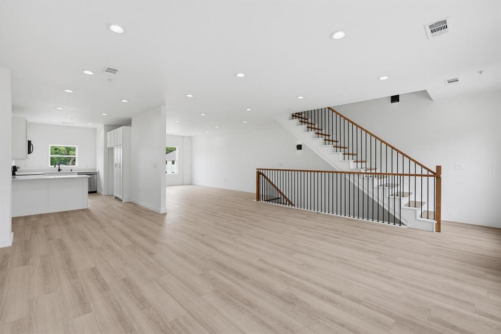 510 South O Connor Road Irving, TX 75060 - Photo 3 of 22 Open-concept living area featuring wood-finish flooring, recessed lighting, and a contemporary staircase with dark balusters and wood handrails